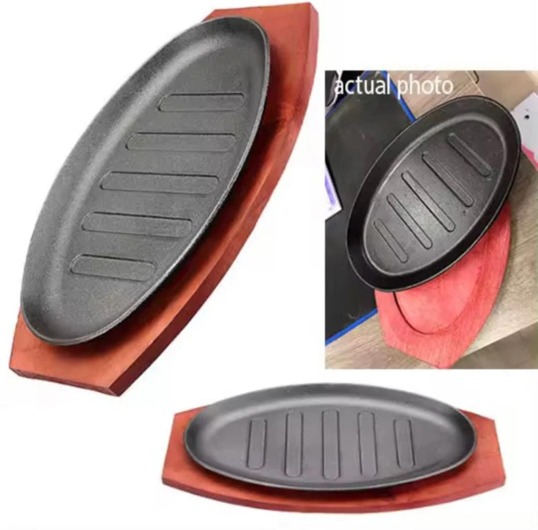 Cast iron hot sizzling plate on wooden tray, available in round and oval shape