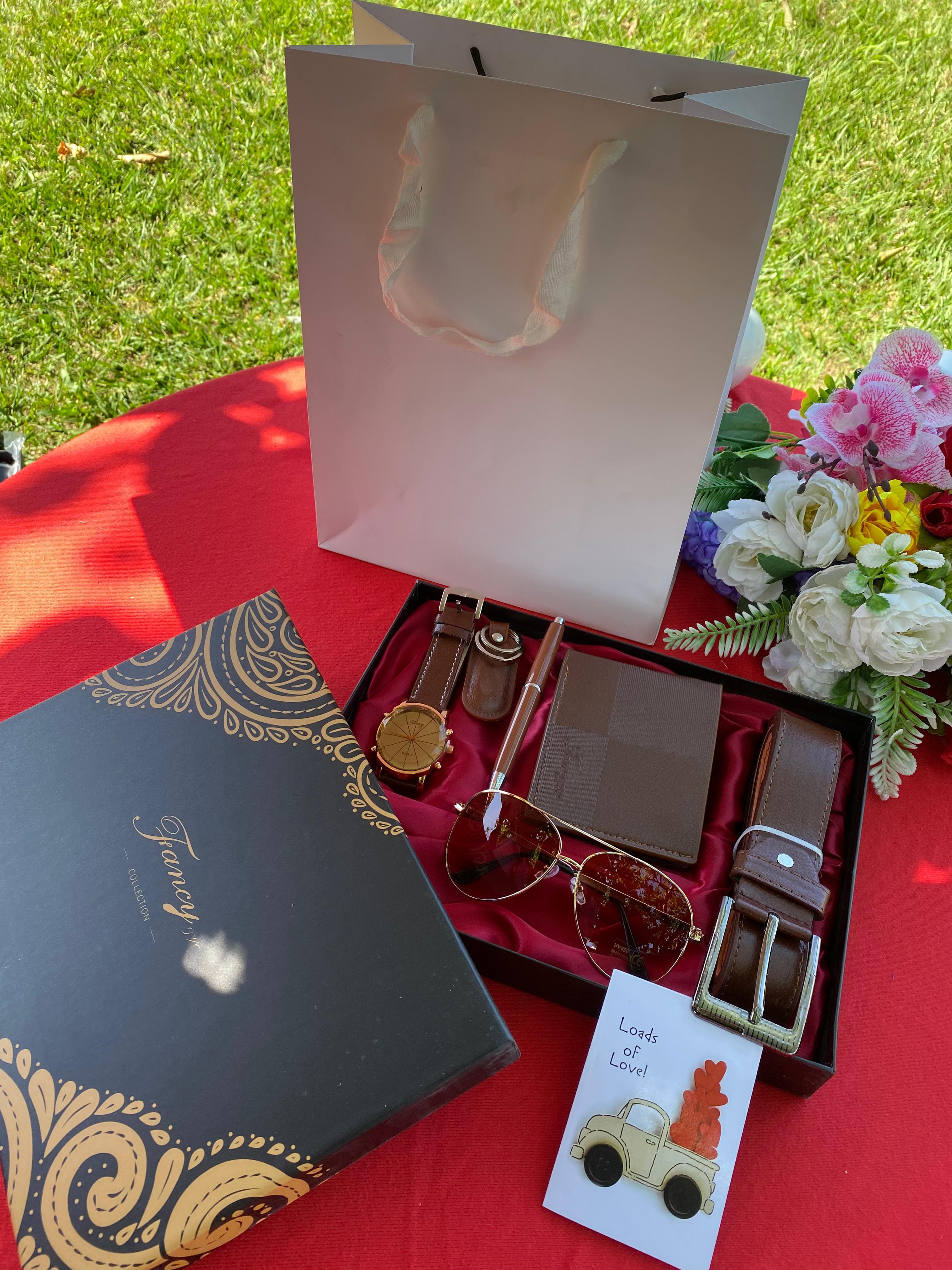 MEN'S VALENTINE GIFT SET. Consists of highly fashioned watch, sunglasses, belt a wallet an executive pen a key holder a gift card and a gift bag