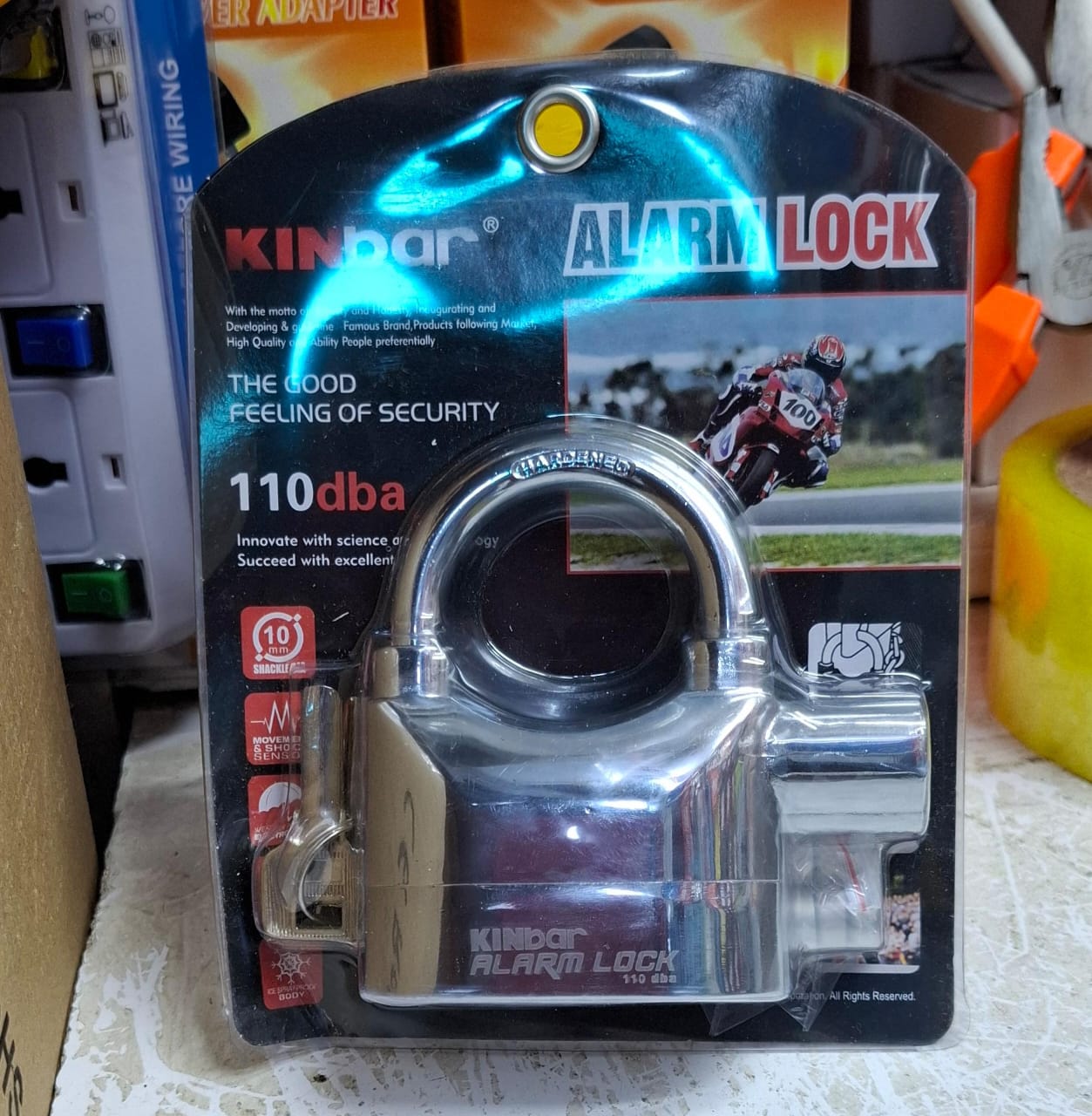 Kinbar High-Security Alarm Padlock. 
It features a built-in movement and shock-triggered sensor alarm. 
The siren is a loud 110dB. 
It has a durable zinc alloy body and hardened steel shackle. 
It can