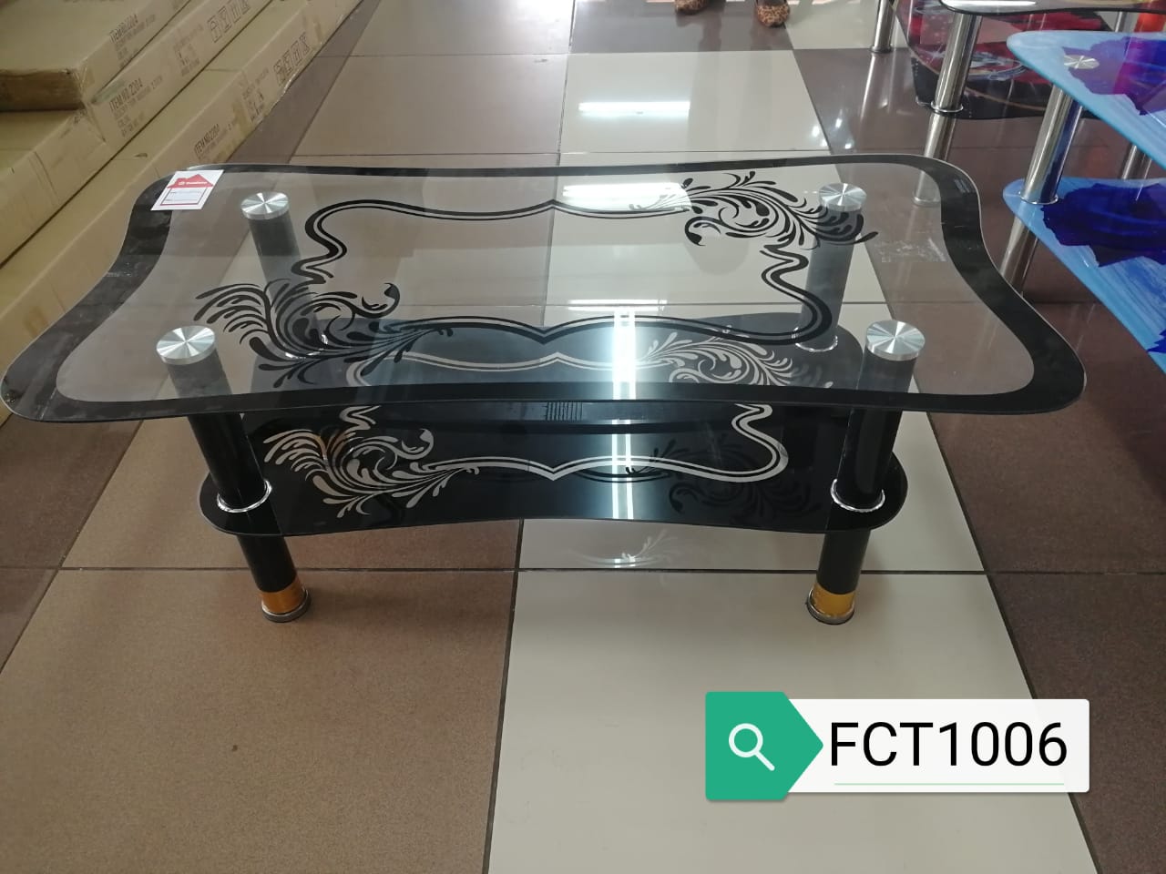 executive glass coffee table.
This type of coffee table features a tempered glass top, which is waterproof, scratch-resistant, and easy to clean. The table has a dark-colored base with decorative patt
