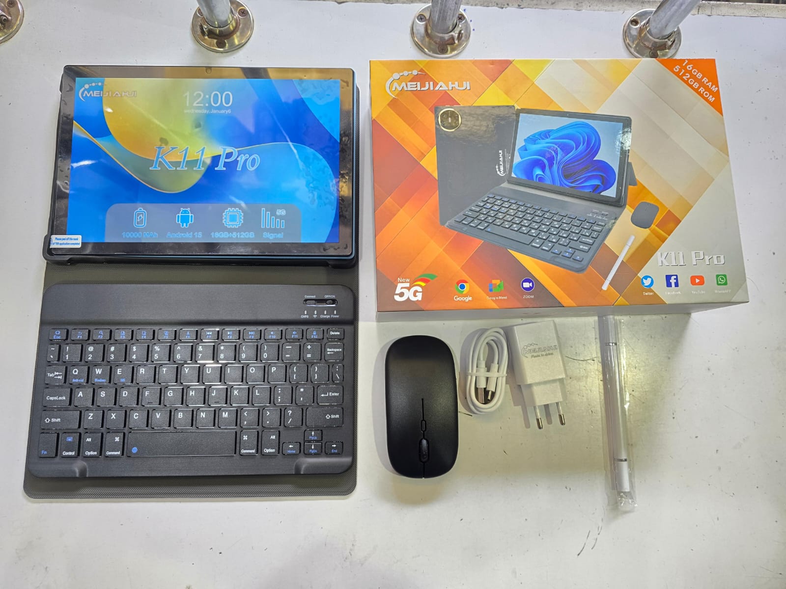 K11 Pro tablet and its accessories.
The product is a tablet computer with a set of accessories, including:
A detachable keyboard
A wireless mouse
A stylus pen
A charging adapter and cable
The box indi