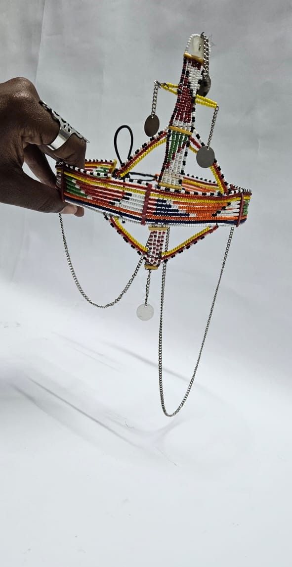 A large red green maasai head gear with some silver daggling decorations very fashionable  and is easy and comfortable to wear