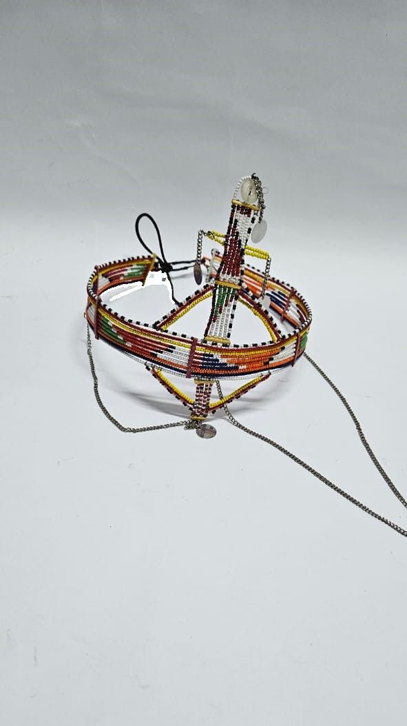 A large red green maasai head gear with some silver daggling decorations very fashionable  and is easy and comfortable to wear