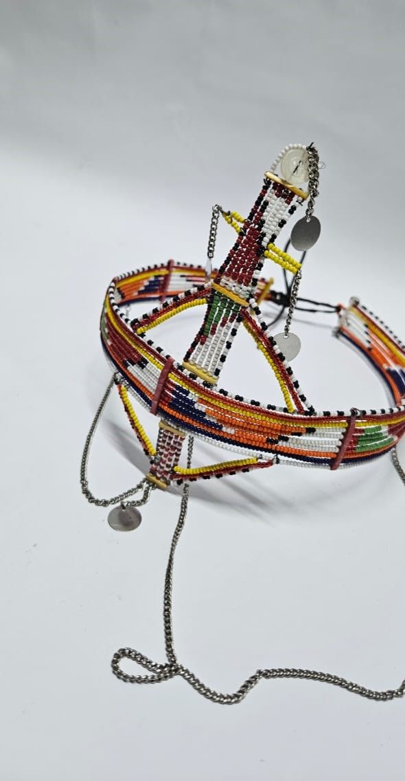 A large red green maasai head gear with some silver daggling decorations very fashionable  and is easy and comfortable to wear