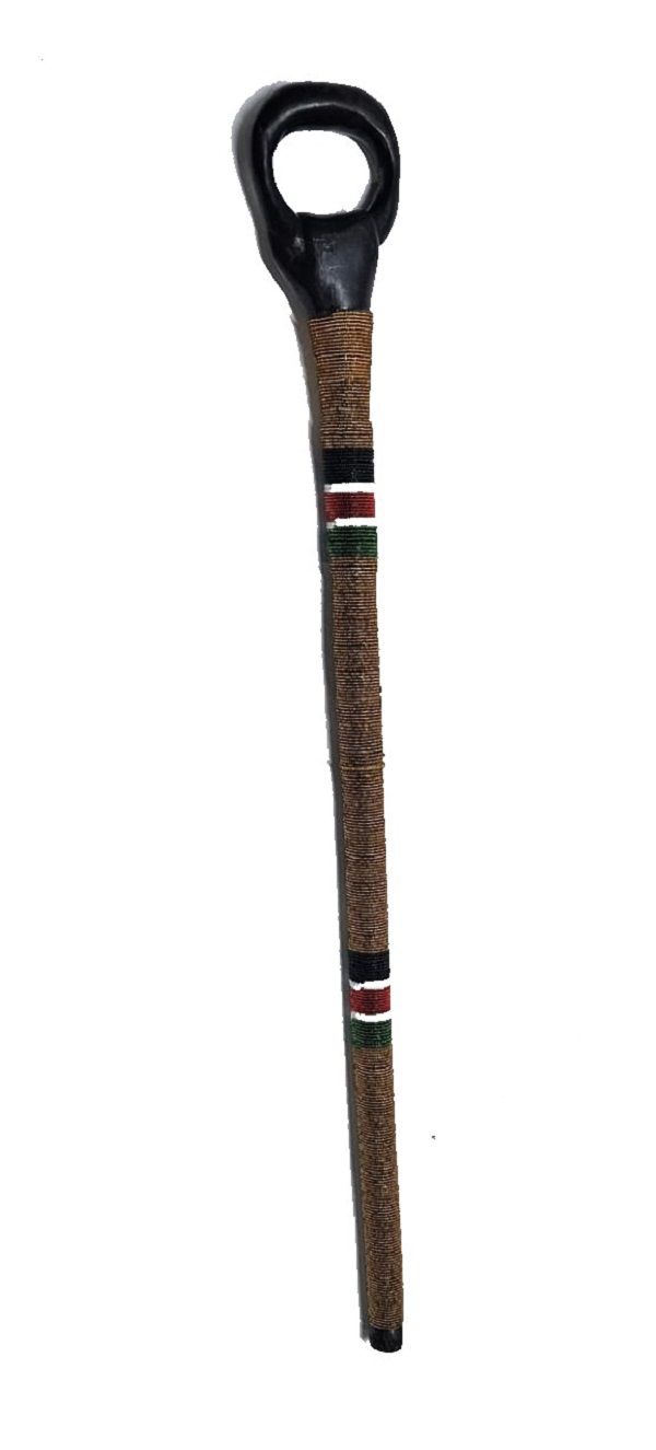 A  black wooden  gold,red, white, black and green beaded walking stick having a circle handle very fashionable to have