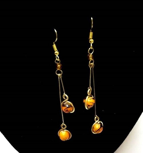Ladies orange crystal drop down earrings are a stunning and elegant accessory designed to add a touch of color and sparkle to any outfit