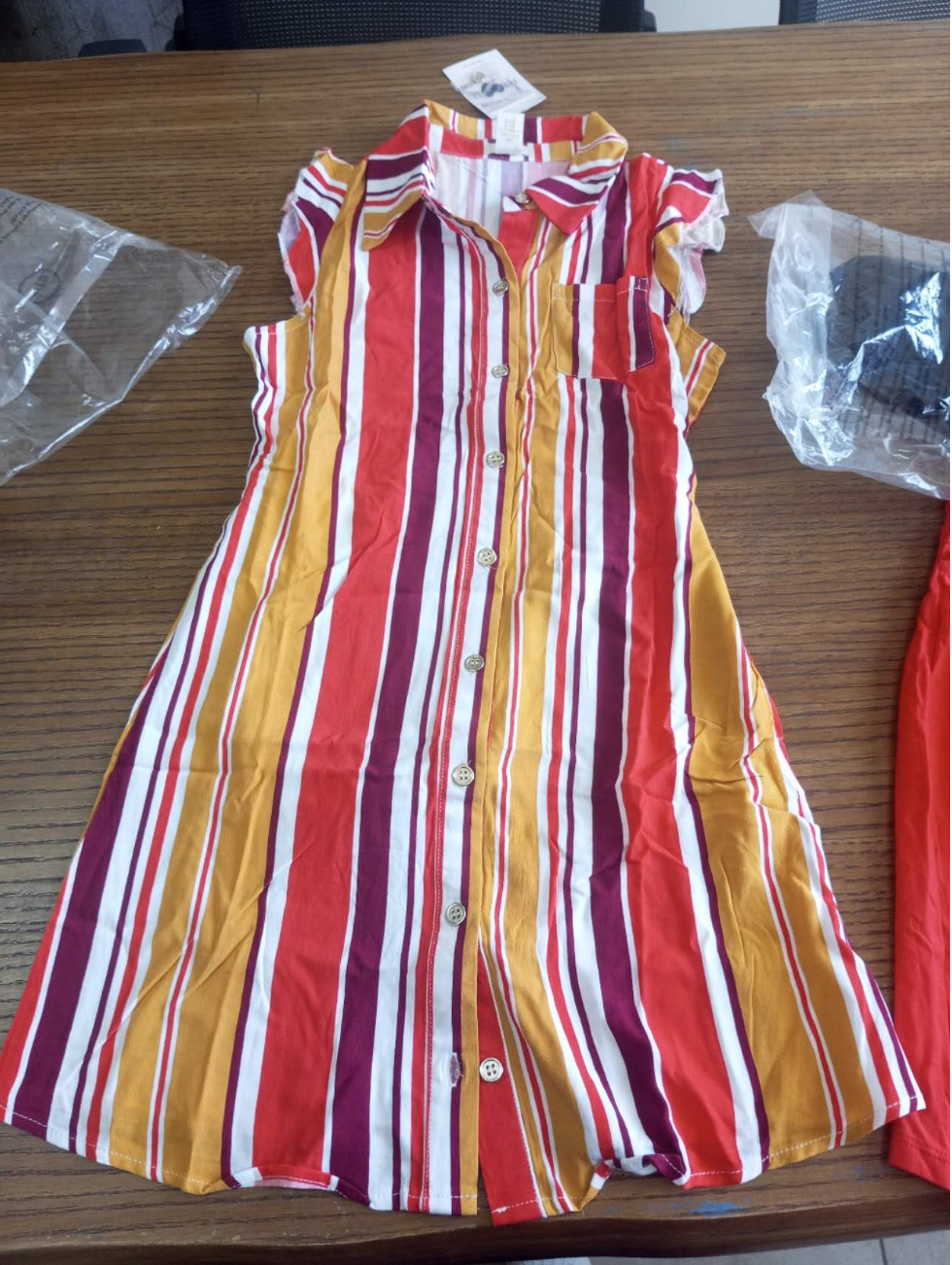Women’s Sleeveless Striped Ladies Shirt Is designed For Comfort And Fashion. Featuring A Bold Vertical Stripe Pattern In Vibrant Shades Of Red, Orange, Yellow And White,