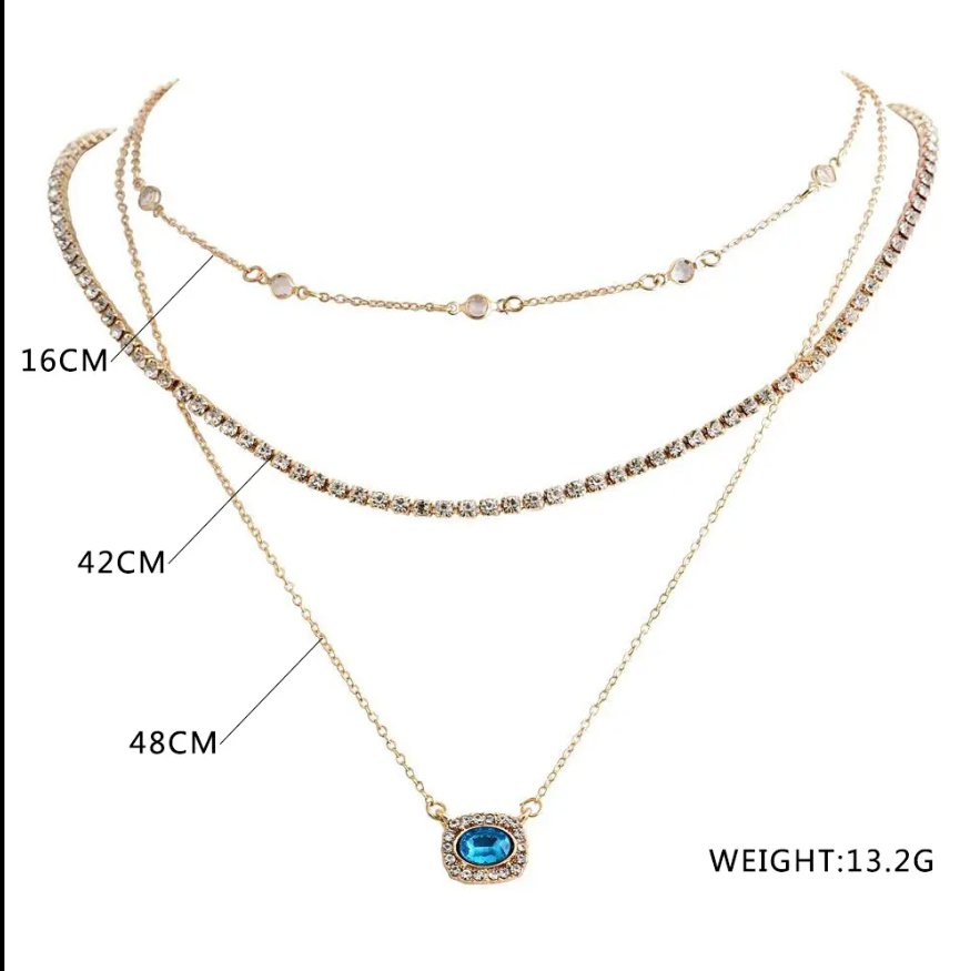 Elegant Multi-Layered Gold Necklace With Blue Gem Pendant. Designed To Enhance Any Outfit, This Piece Is Perfect For Formal Occasions, Casual Wear, Or As A Statement Accessory