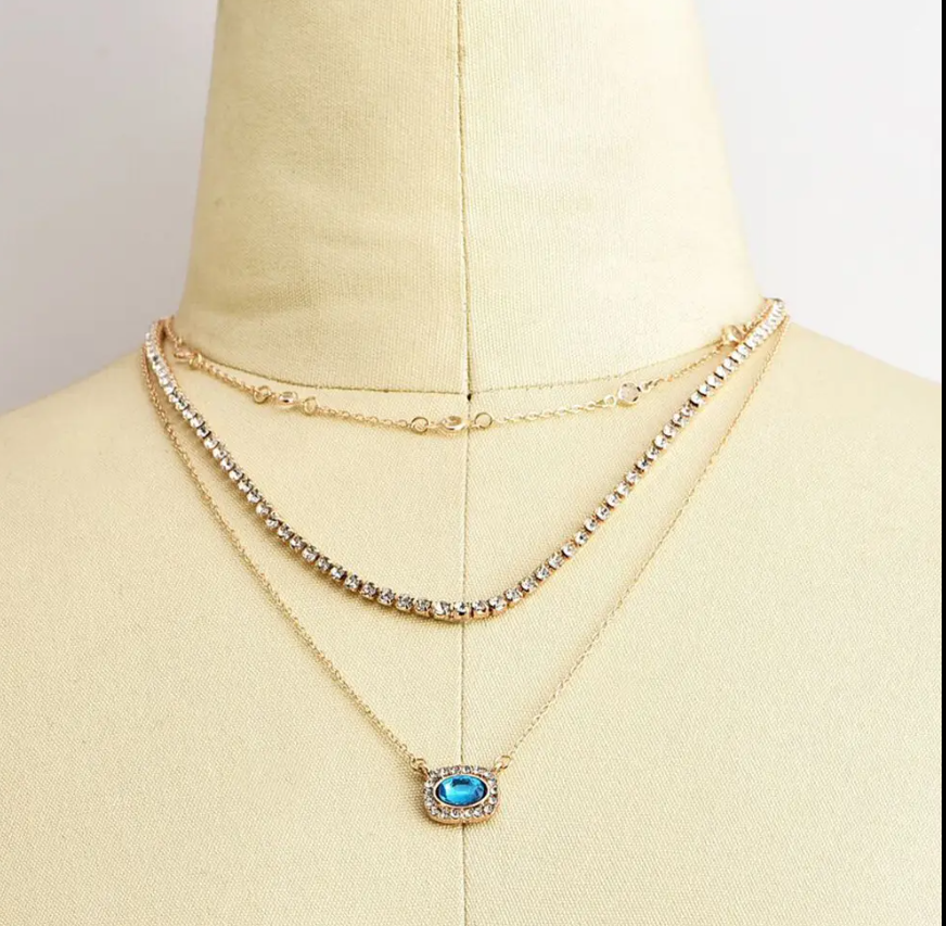 Elegant Multi-Layered Gold Necklace With Blue Gem Pendant. Designed To Enhance Any Outfit, This Piece Is Perfect For Formal Occasions, Casual Wear, Or As A Statement Accessory