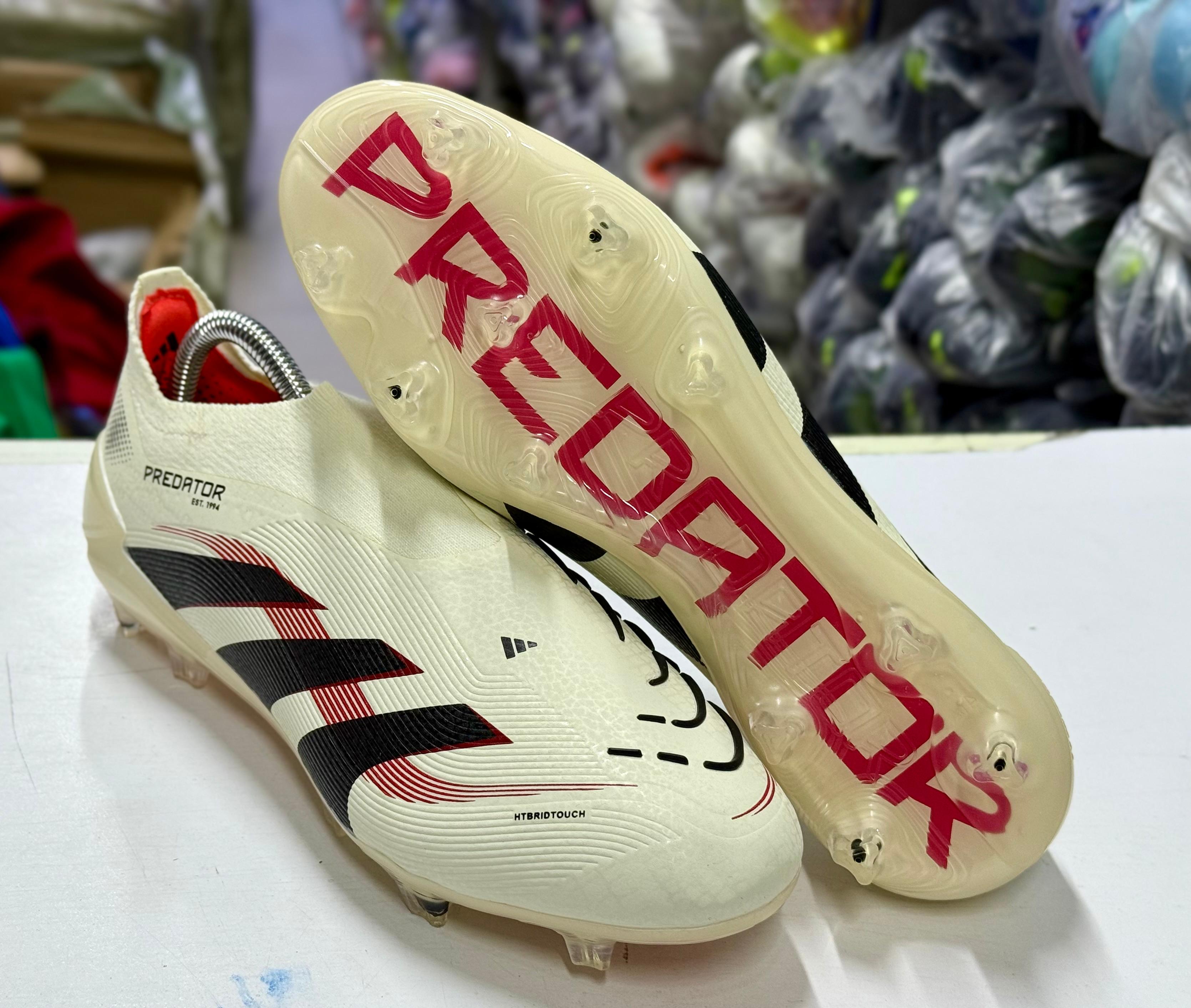 Predator Elite Laceless Firm Ground football boots in an off-white and core black colorway.
