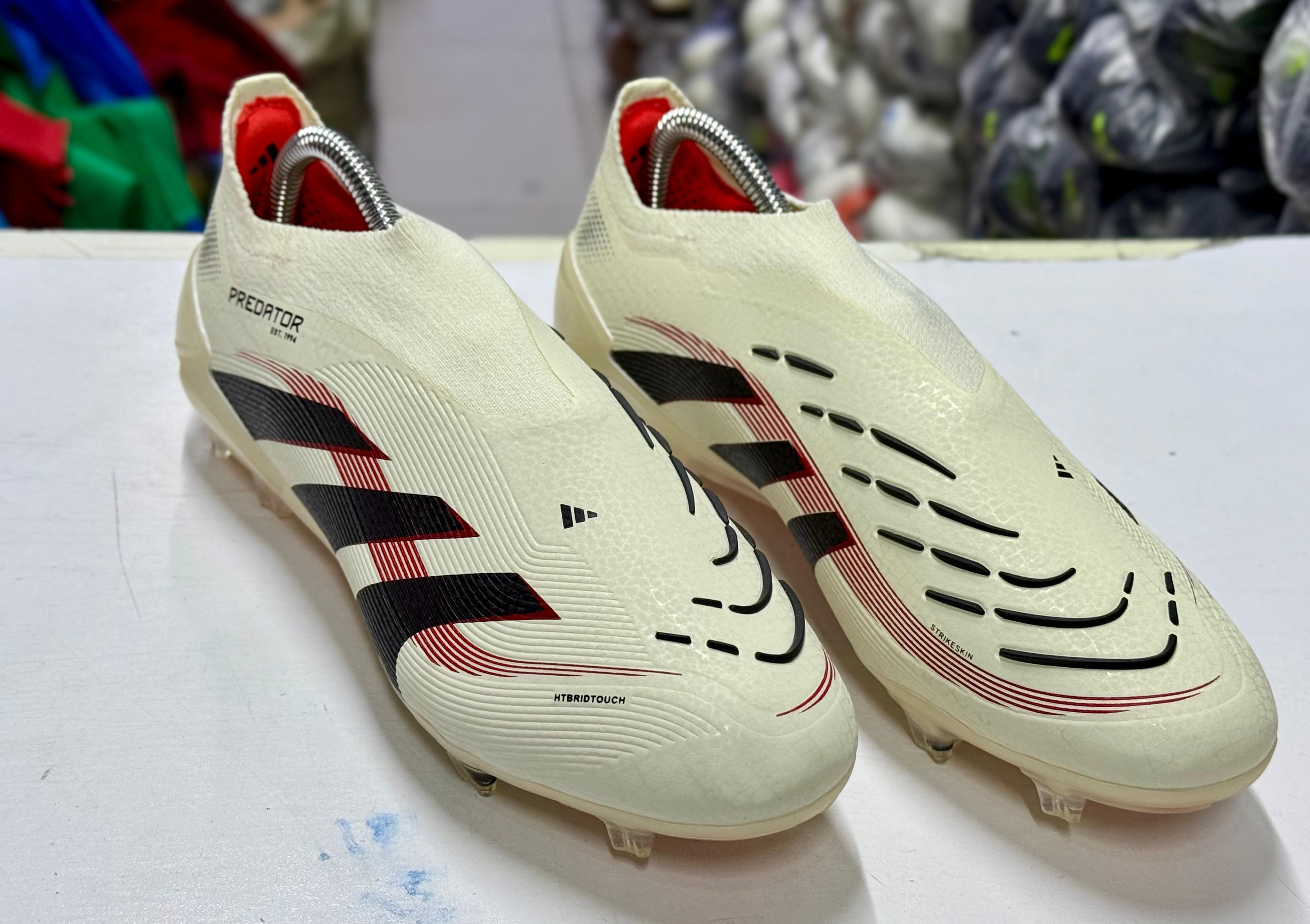 Predator Elite Laceless Firm Ground football boots in an off-white and core black colorway.