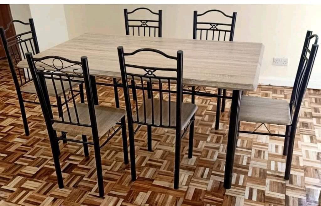 Executive 6 sitter dinning table Executive 6-Seater Dining Table, designed to combine elegance, durability, and comfort. The set includes a rectangular table with a light grey wood-finish top and stur