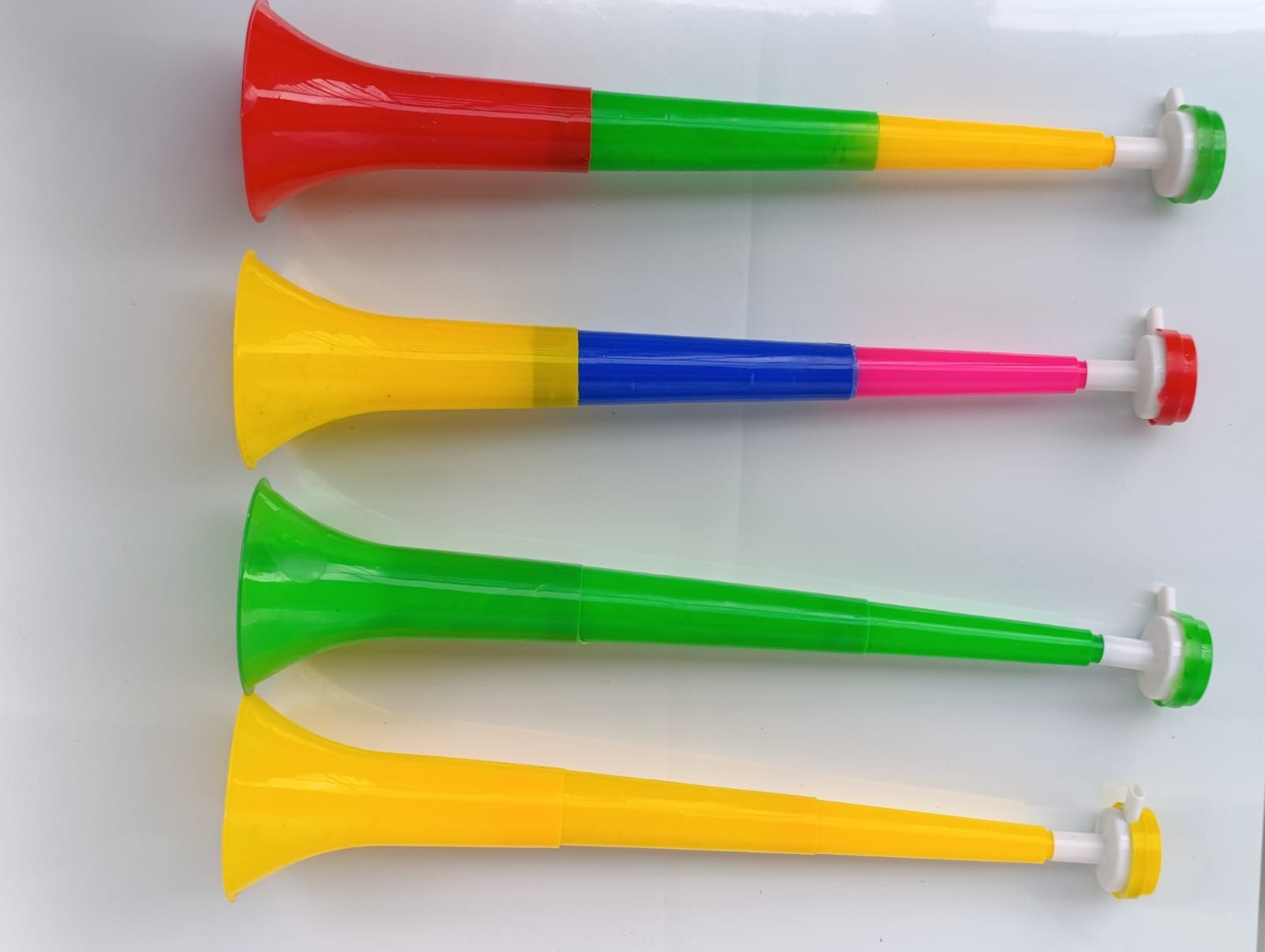 A set of 4 Vuvuzela Stadium Horns Cheerleader Trumpets Cheerleading horns Fun Stadium Noisemakers Easily Collapsible to fit in backpacks Easy to Operate; just blow it. Colourful & Fun,