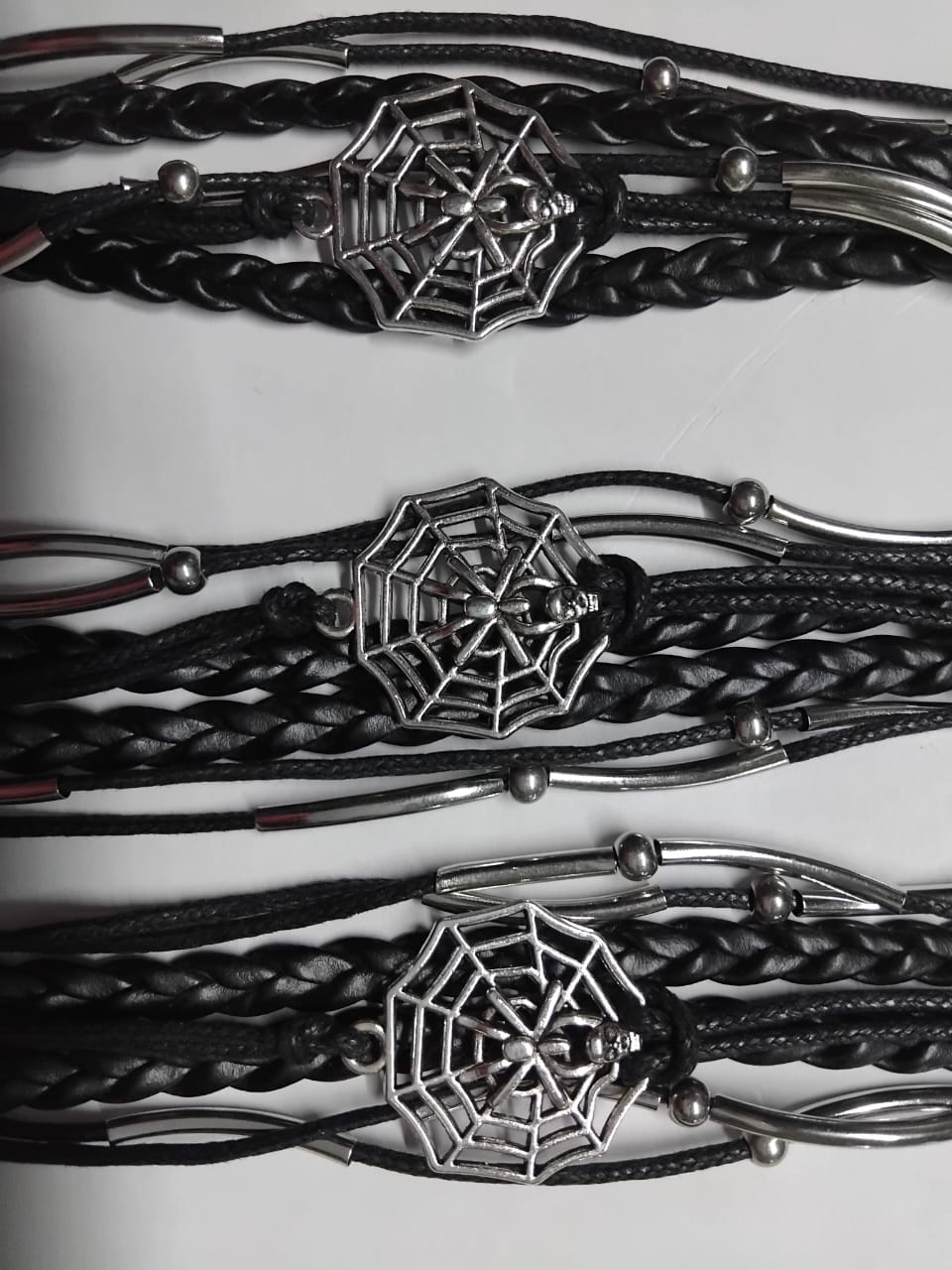 A multi-strand leather bracelet adorned with cobweb decorations sounds like a unique and edgy accessory