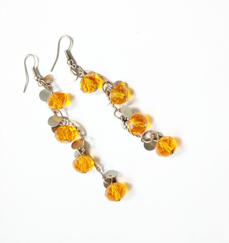 orange crystal long earrings are a striking accessory that exudes elegance and charm The earrings are crafted from high-quality materials