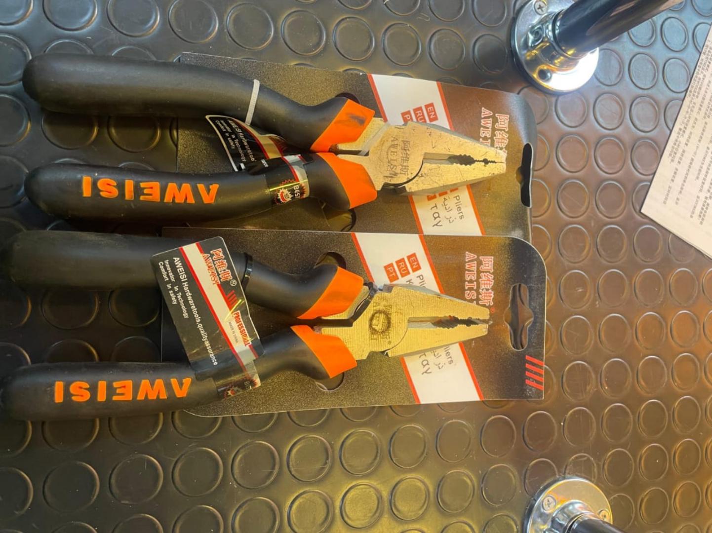 Combination pliers packaged with ergonomic black and orange rubber handles and a polished metal head.