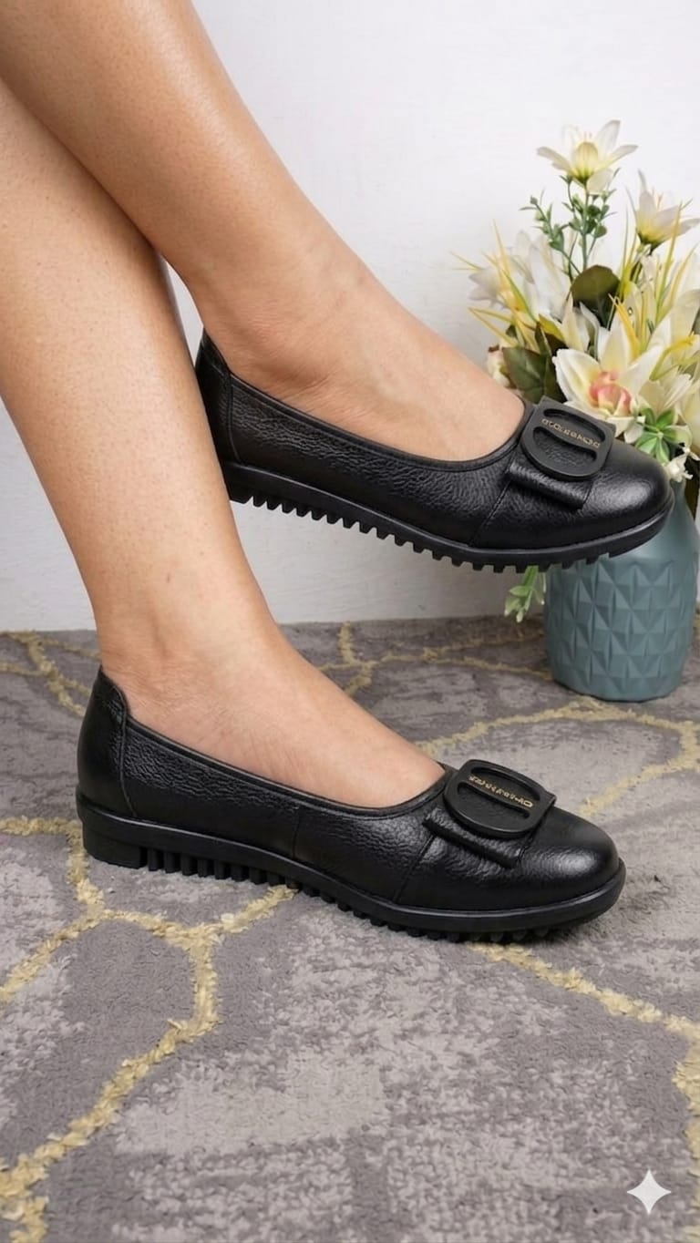 Fashionable black textured leather slip-on ballet flats With  decorative buckle detail and a ridged rubber outsole.