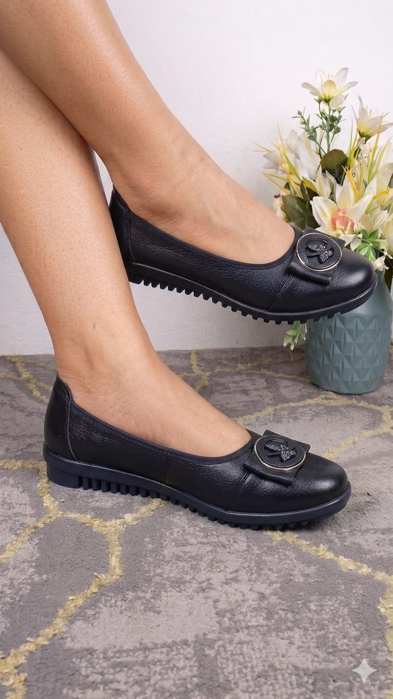 Fashionable black textured leather slip-on ballet flats With  decorative buckle detail and a ridged rubber outsole.
