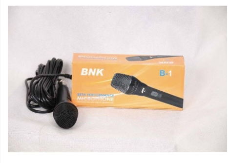 NK B-1 wired handheld dynamic microphone placed beside its original packaging box, on/off slider switch located in the middle of the microphone’s handle for easy control during use.