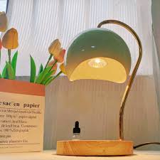 Nordic-style electric candle warmer lamp features a green hemispherical shade and a natural wood base