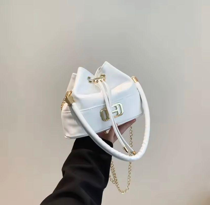 Mini leather sling bag; White elegant mini size leather shoulder handbag with drawstring closure. It comes with a handle. It's perfect for casual outings, work, travel, parties, and special occasions.
