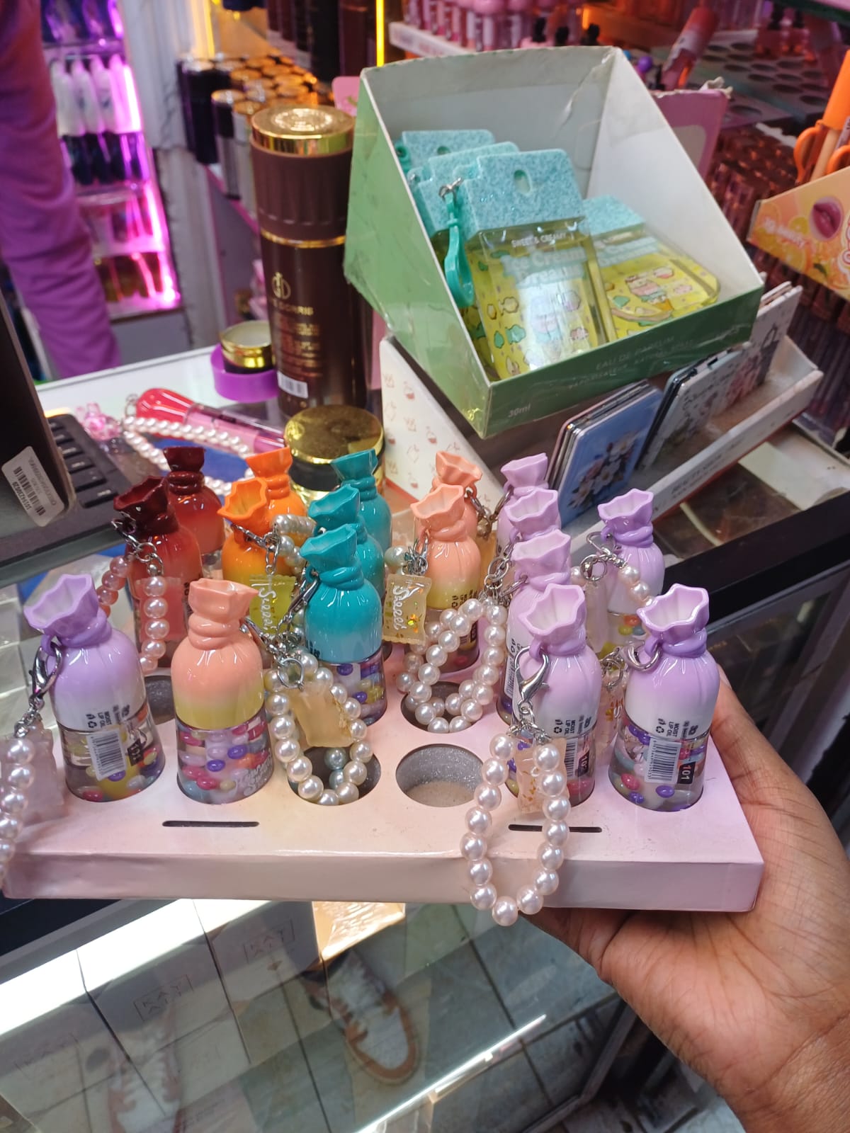 Candy-shaped mini lip oil attached to elegant pearl-beaded wristlet keychains.