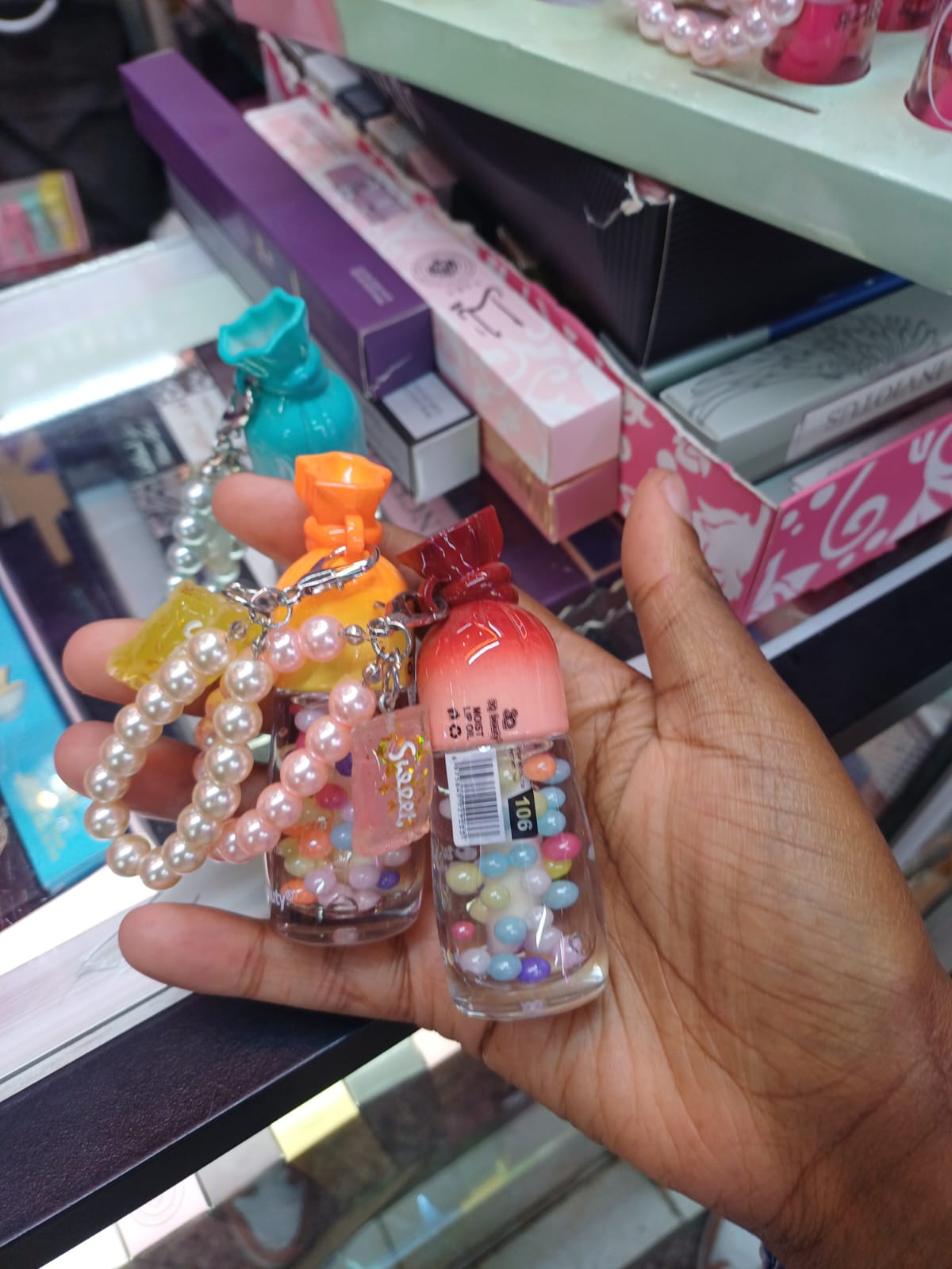 Candy-shaped mini lip oil attached to elegant pearl-beaded wristlet keychains.