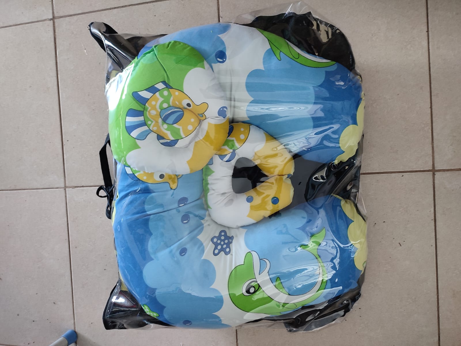 multi-functional baby nursing and feeding pillow set, tightly packed inside a clear plastic protective travel bag with a black zipper trim and handles.Ergonomic Baby Nursing Pillow  Lounger with cover
