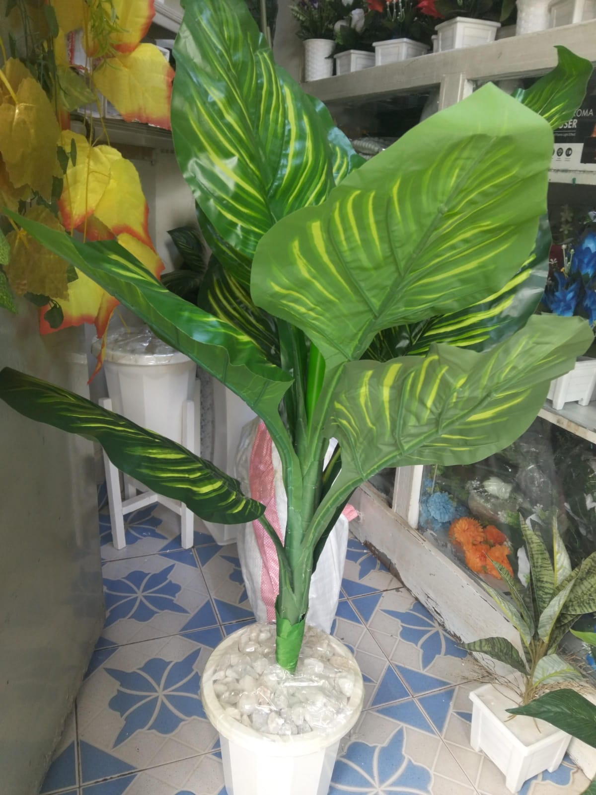 Artificial Flower Arrangement Set  Decor Stones Plus A Vase is an exquisite home decor piece designed to elevate your living space. This set includes a beautifully crafted plastic vase m
